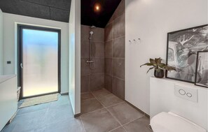Ein modernes Badezimmer mit Dusche, Toilette und Waschbecken.