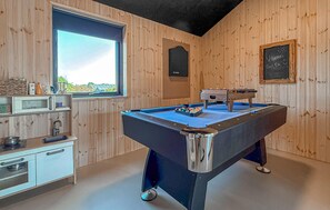 A room with a pool table, a window with a view, a chalkboard with writing, and wooden walls. - Lovely home in Børkop with sauna (Børkop)