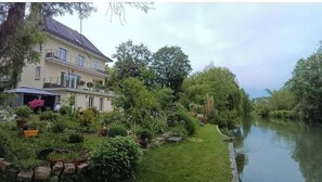 Ein zweistöckiges Haus mit Garten und Kanal.