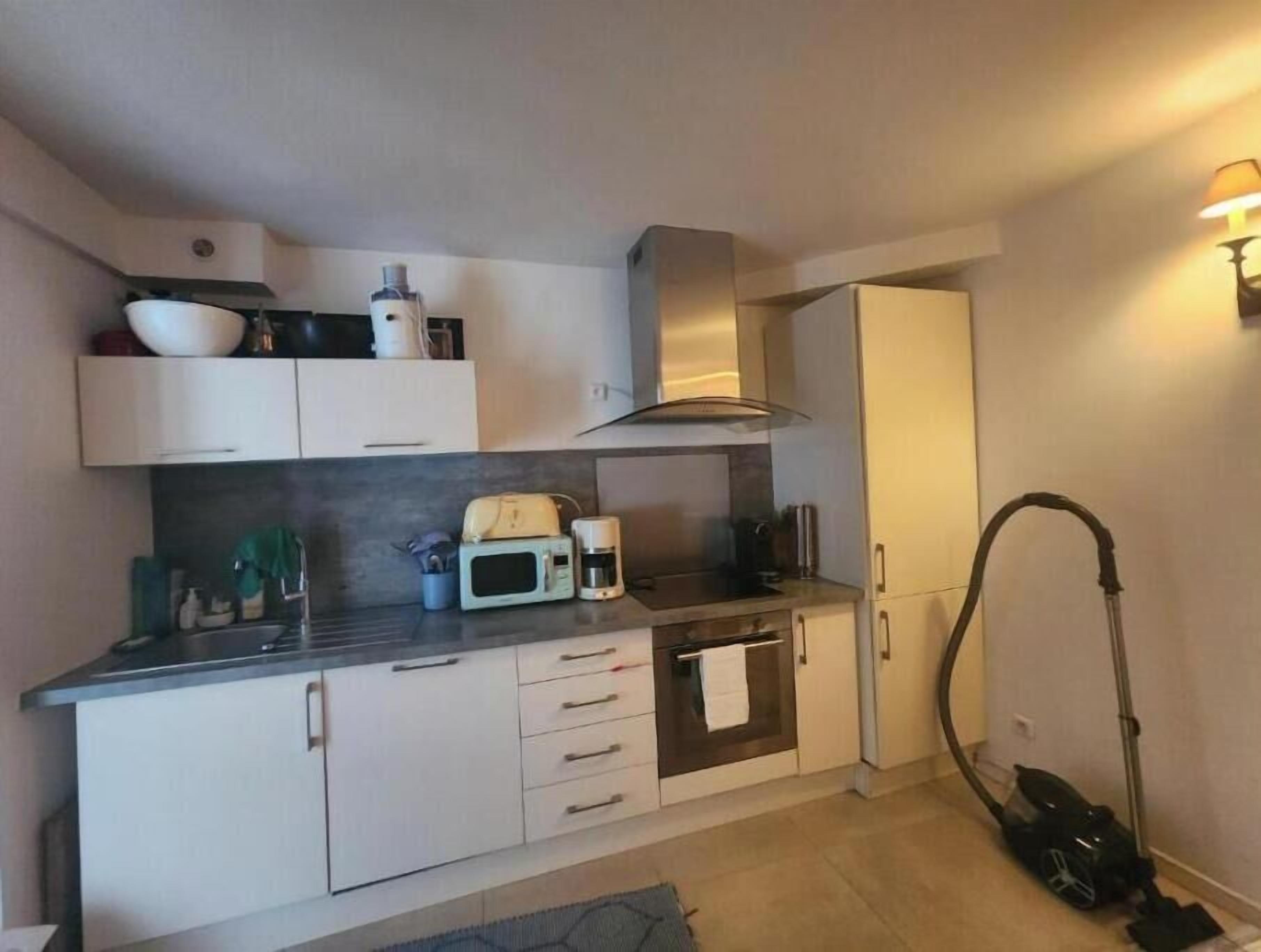 A compact kitchen with a microwave, oven, and sink.
