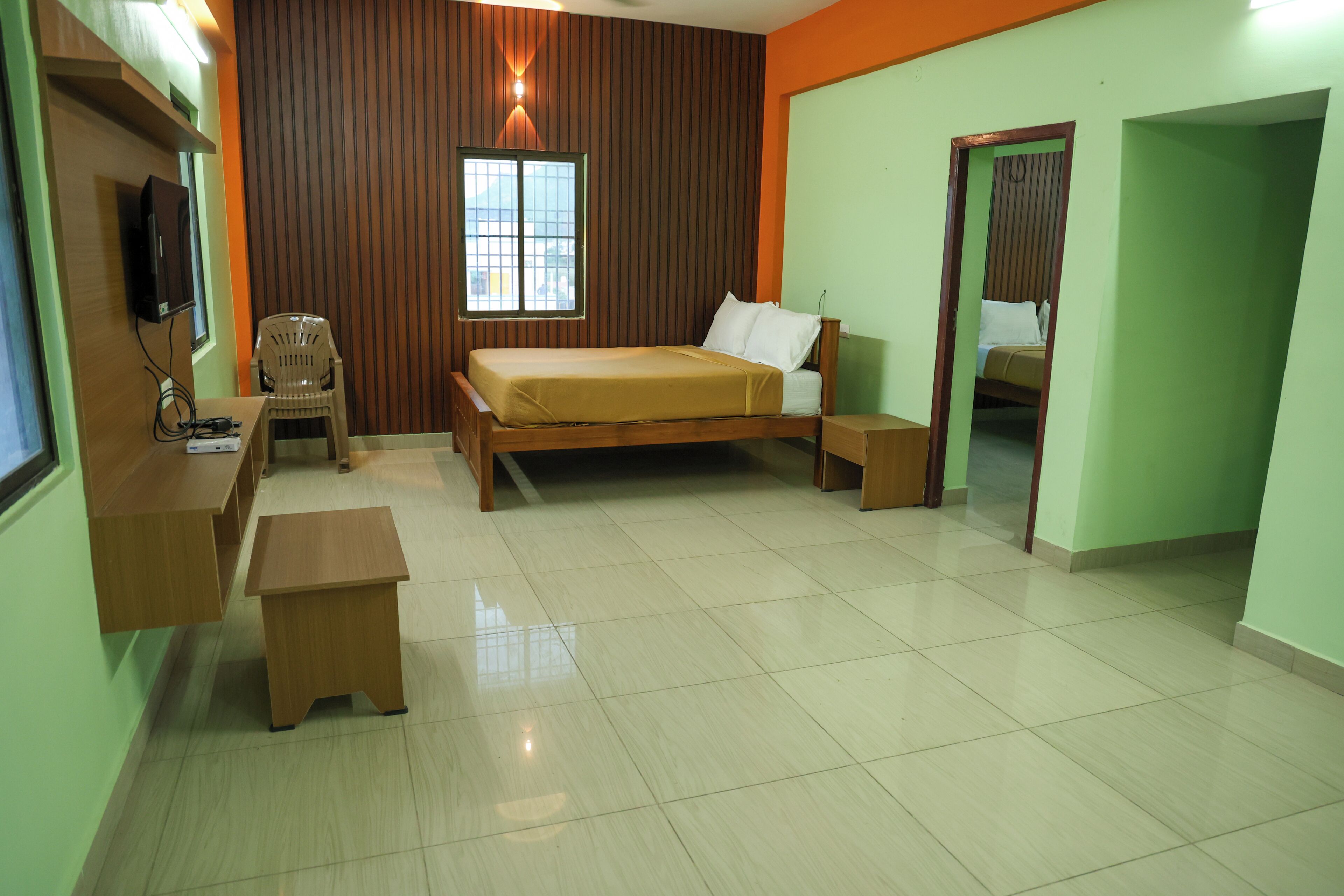 A room with a bed, a desk, a chair, and a mirror.