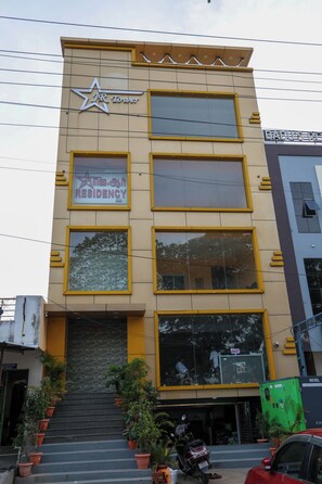 A multi-story building with a star logo and 'JR Tower' signage. - Sri Mahadeepam Residency (Tiruvannamalai)