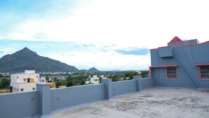 A rooftop terrace with a view of a mountain and surrounding buildings.