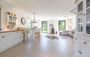 A spacious kitchen with a dining area, a fireplace, and a sofa in a bright, modern interior. - Cozy home in Dassow OT Rosenhagen with WiFi (Dassow OT Rosenhagen)