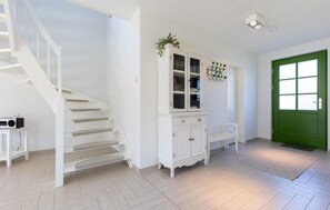 A staircase, a white cabinet with glass doors, a green door, and a white chair. - Cozy home in Dassow OT Rosenhagen with WiFi (Dassow OT Rosenhagen)