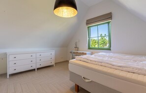 A bedroom with a bed, a dresser, a window with a view, and a hanging light fixture. - Cozy home in Dassow OT Rosenhagen with WiFi (Dassow OT Rosenhagen)