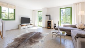 Ein modernes Wohnzimmer mit Flachbildfernseher, Kamin, Sofa und Couchtisch.