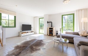 A modern living room with a flat-screen TV, a fireplace, a sofa, and a coffee table. - Cozy home in Dassow OT Rosenhagen with WiFi (Dassow OT Rosenhagen)