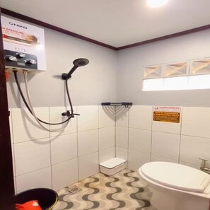 Ein kleines Badezimmer mit Dusche, Toilette und Waschbecken.