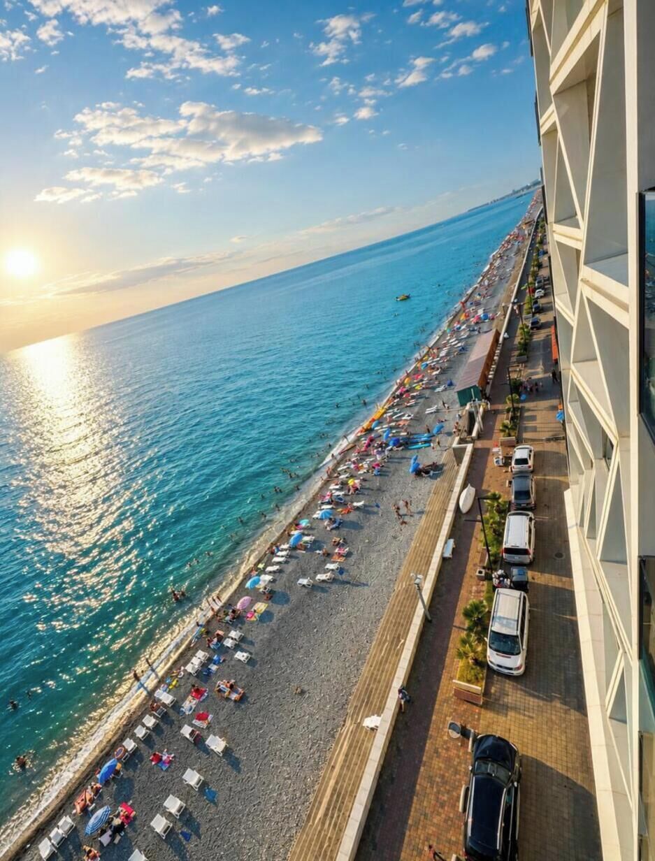 A beachside view from a balcony overlooking a crowded beach with umbrellas and people.
