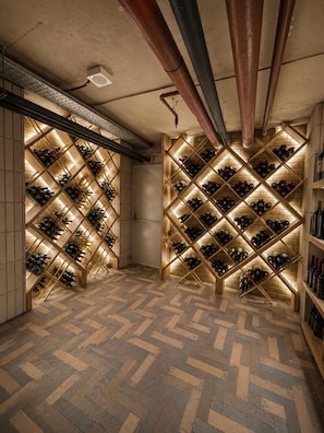 A wine cellar with wooden racks and a herringbone floor pattern. - The New Jai Son (Kobuleti)