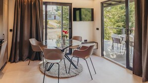 Un comedor moderno con una mesa de vidrio, sillas y un tapete redondo.