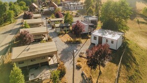 Una zona residencial con varias casas, un edificio central con un techo grande y un edificio blanco pequeño a la derecha.