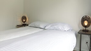 A bed with white bedding, two bedside tables with lamps, and a wall socket. - The bungalow Palthe Comfort offers comfort and tranquility in nature for 4 people, with modern amenities and a lovely terrace. (Nieuw Heeten)