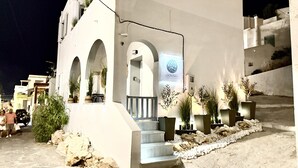 Un edificio con fachada blanca, varios arcos y un letrero que indica que es un estudio premium.