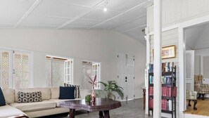 A spacious living room with a sofa, a round coffee table, and a bookshelf. - Pvt Villa Estate With Mtn Views Pool in Ocho Rios (Labyrinth)