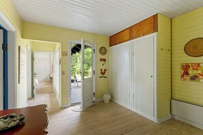 Ein Zimmer mit Holzboden, einer geschlossenen Tür und einem Fenster.
