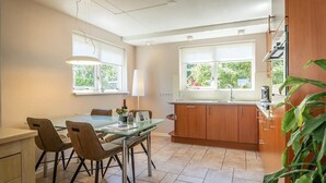 Eine moderne Küche mit Esstisch, Stühlen und einem Fenster.