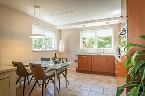 Eine moderne Küche mit Esstisch, Stühlen und einem Fenster.