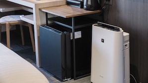 Eine kleine Küchenzeile mit Kühlschrank, Kaffeemaschine und Mikrowelle.