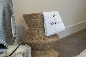 A textured, woven object with a white cloth labeled 'THE KODRIAN' draped over it. - Family Room, The Kodrian (Athens)