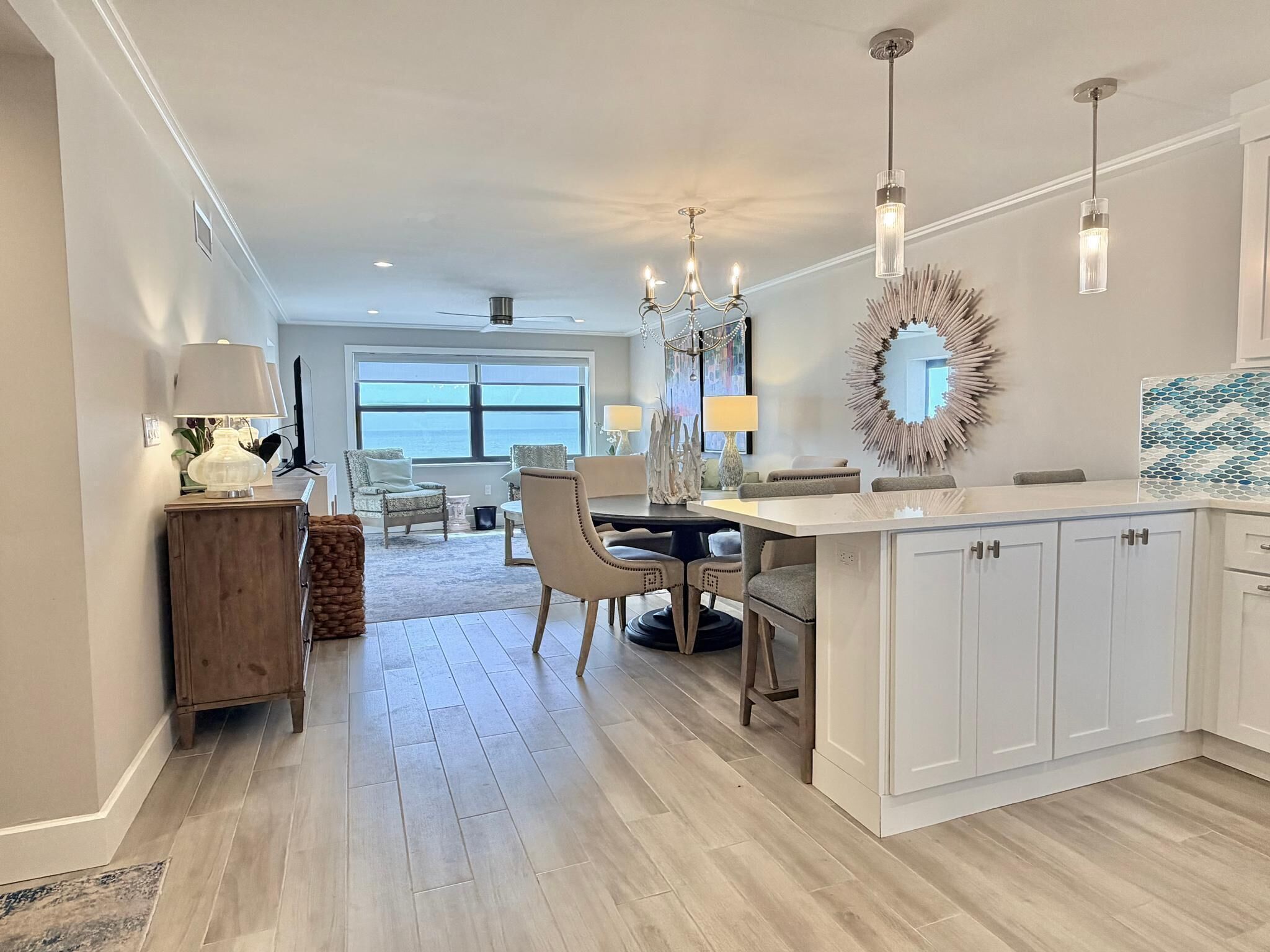 A spacious kitchen with a dining area, large windows, and a view of the ocean.