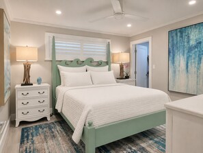Ein Schlafzimmer mit einem Bett, Nachttischen, einer Kommode, einem Deckenventilator und einem großen abstrakten Gemälde.