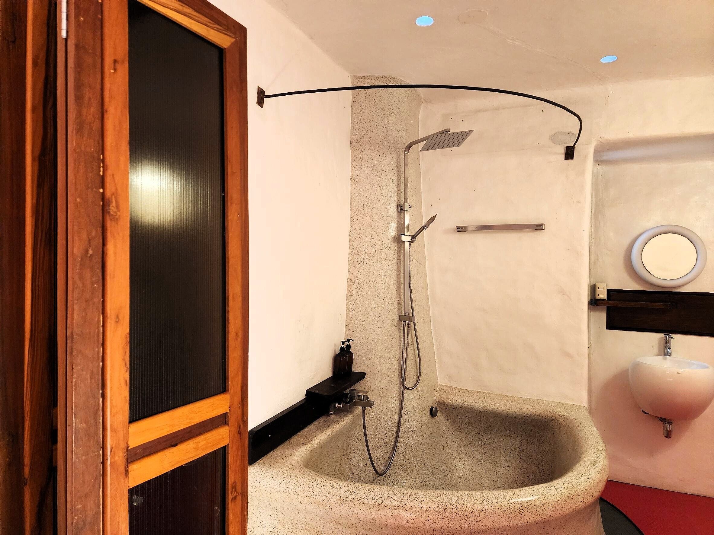 A bathroom with a shower, sink, and mirror.