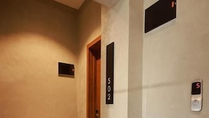 A hallway with a door labeled '502' and a digital elevator control panel displaying the number '5'.