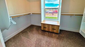 A corner room with a window, carpeted floor, and built-in bench. - Modern Teton Valley Townhome w/AC + Garage (Driggs)