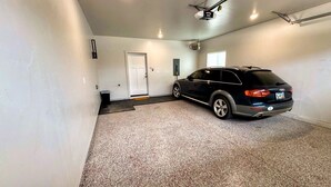 A parking garage with a single black SUV parked in a space. - Modern Teton Valley Townhome w/AC + Garage (Driggs)