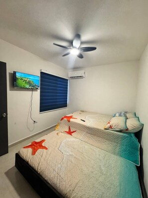A bedroom with a bed, a ceiling fan, an air conditioner, a TV on the wall, and a window with blinds. - Depto Arrecifes 2 min a Playa Miramar  (Ciudad Madero)