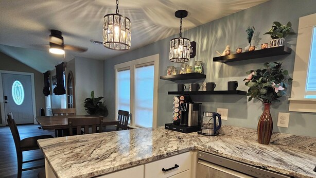 A modern kitchen with a marble countertop, stainless steel appliances, and pendant lighting. - Serene 2-bedroom house with AC in charming Houghton Lake (Houghton Lake)