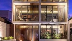 Ein mehrstöckiges Gebäude mit modernem Design, mit Balkonen und großen Fenstern.