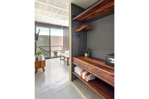 Une salle de bain moderne avec un meuble-lavabo en bois, un porte-serviettes et une plante en pot.