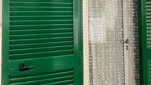 Una puerta verde con manija, un cactus decorativo y un cartel que dice 'Dimora nel Vico'.