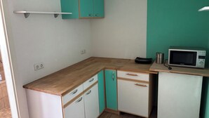 Eine Küche mit Mikrowelle, Schränken und einer Arbeitsplatte.