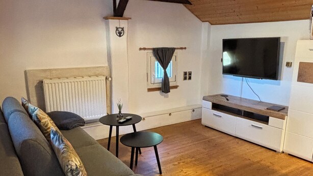 Een gezellige woonkamer met een bank, een salontafel en een televisie.