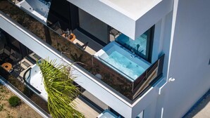 A modern building with a rooftop pool and outdoor seating.