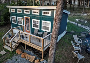 A small wooden cabin with a porch, multiple windows, and a door. - Liberty-Cabin-2 @ Eagle Hollow (goreville)