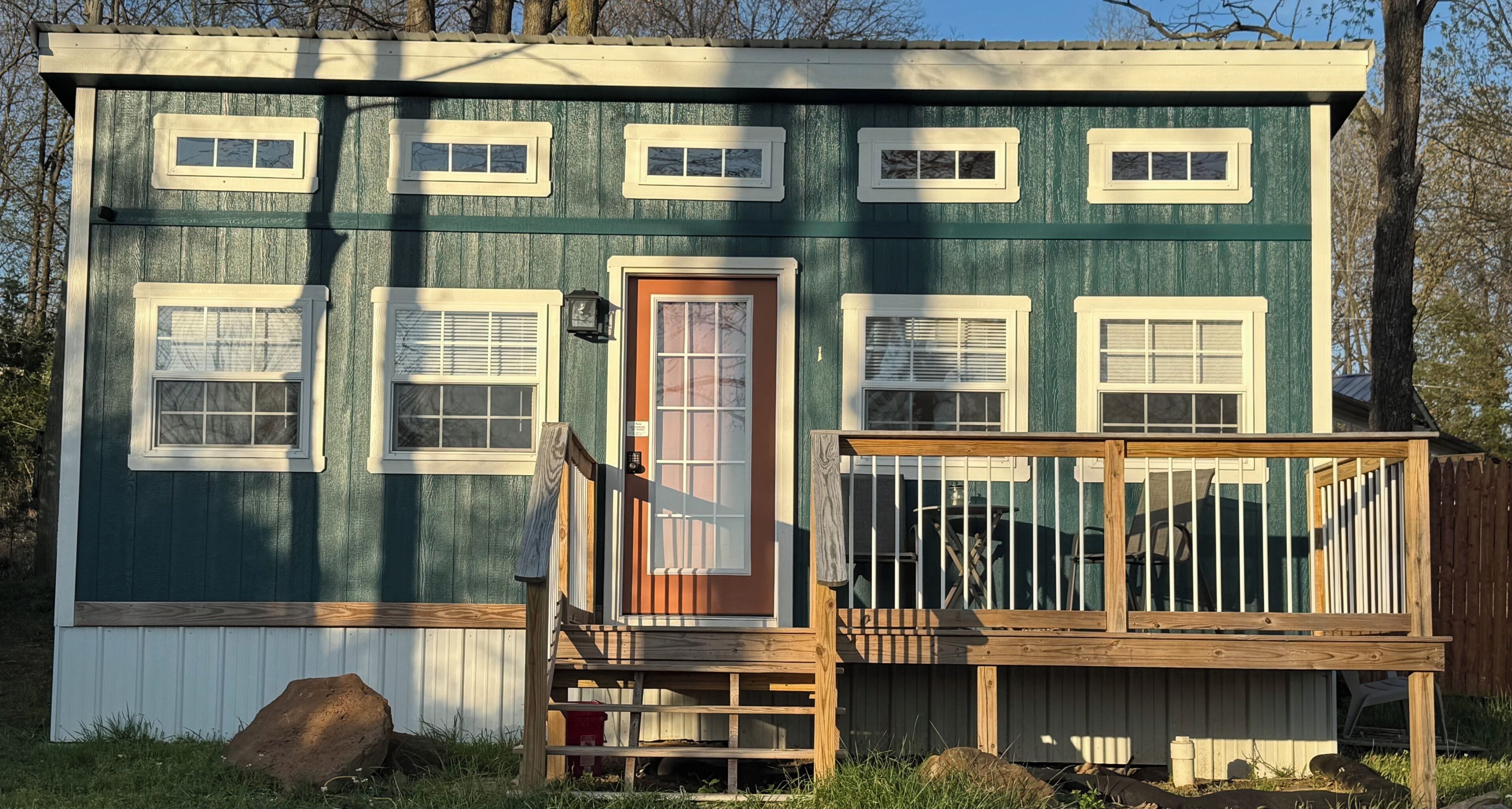 A two-story house with a front porch, multiple windows, and a door.