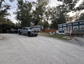 A gravel driveway leading to a building with a green exterior and white trim. - Justice-Cabin-3 @ Eagle Hollow (goreville)