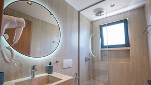 A modern bathroom with a large mirror, a sink, a toilet, and a shower. - Villa Epic (Sarande)