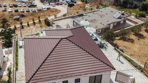 A coastal property with a tiled roof, a swimming pool, and a parking area. - Villa Epic (Sarande)