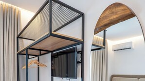 A modern hotel room with a bunk bed, a wooden table, a mirror, and a bed with a headboard. - Villa Epic (Sarande)