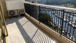 Ein Balkon mit Blick auf eine Marina, eine Samsung-Klimaanlage und ein Fliesenboden.