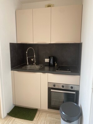 A compact kitchen with a sink, a coffee maker, a stove, and a trash bin. - Cannes Marina Studio with Harbor View, Pool (Mandelieu-la-Napoule)