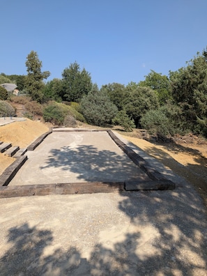 A paved area with a concrete border, surrounded by dense shrubbery and trees. - Villa Verdon (Baudinard-sur-Verdon)