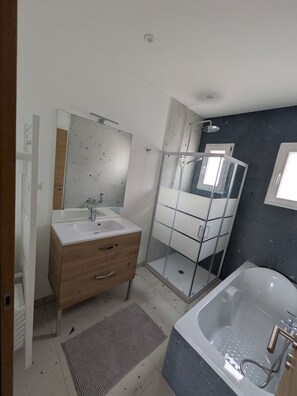 A bathroom with a glass-enclosed shower, a white sink with a mirror, and a bathtub. - Villa Verdon (Baudinard-sur-Verdon)
