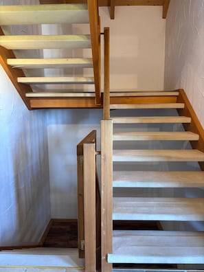 A wooden staircase with a handrail, leading to an upper level. - Waldrausch Vacation Home (Siegsdorf-Vorauf)